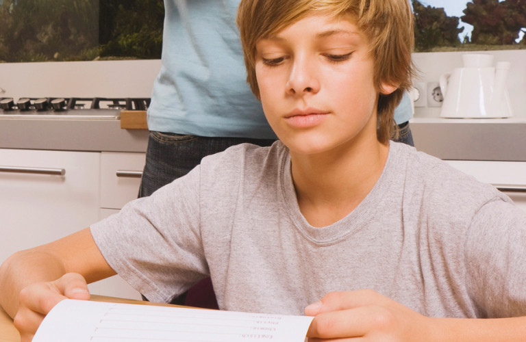 Teenager looking at his report on the table